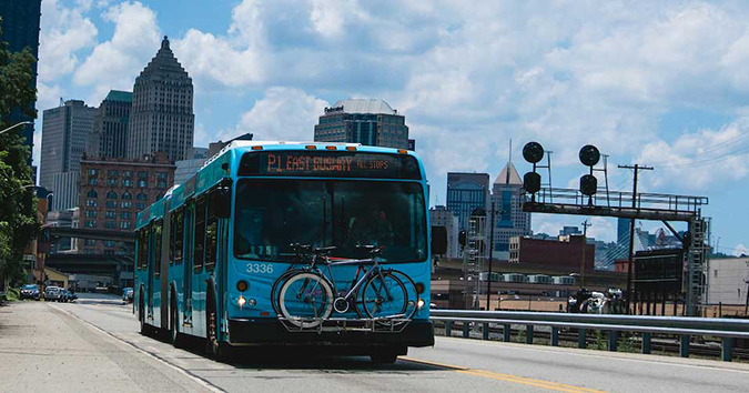 A blue port authority bus travels through Pittsburgh.